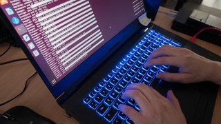 Eine Person eines Landeskriminalamts arbeitet an Computerbildschirmen. Leibfarth vom Chaos Computer Club Stuttgart habe beobachtet, wie die Rechte der Polizei bezüglich der Daten von unschuldigen Bürger:innen in den vergangenen Jahrzehnten immer wieder erweitert worden seien. 