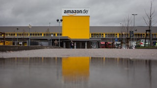 Der Schriftzug des Online-Versandhändlers Amazon ist vor dem Logistikzentrum in Pforzheim zu sehen.