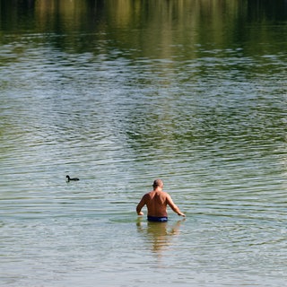 Ein Mann geht zum Schwimmen in den Vogelstangsee.