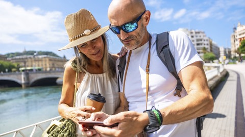 Paar auf Reisen: Statt nur aufs Navi und "Google Maps" zu starren, den eigenen Orientierungssinn stärken - der richtige Weg beginnt mit dem Blick in die Umgebung.