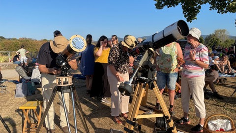 Menschen warten mit ihrem Teleskop auf die Sonnenfinsternis.