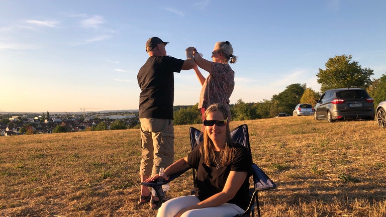 Mehrere Menschen fotografieren die Sonnenfinsternis.