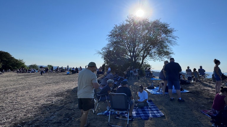 Menschen warten auf die partielle Sonnenfinsternis