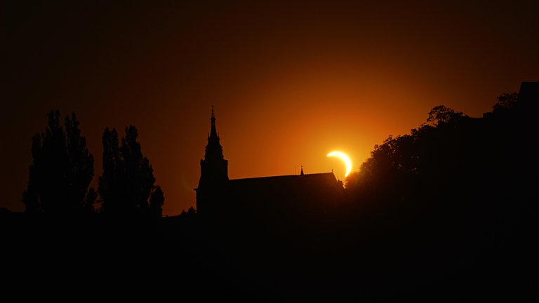 Sonnenfinsternis hinter der Stiftskiche in Tübingen. Das Wetter-Phänomen war am Donnerstagabend über dem Himmel in Baden-Württemberg zu beobachten.