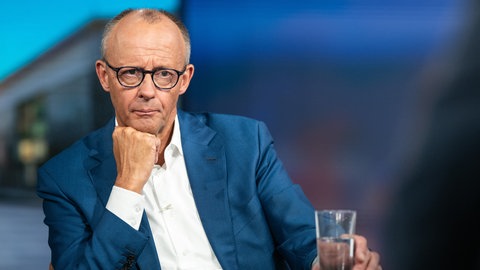 Bundeskanzler Friedrich Merz (CDU) sitzt an einem Tisch.