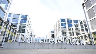 Das Logo von Daimler Truck steht vor der Zentrale des Unternehmens. Der Nutzfahrzeughersteller Daimler Truck will bis Ende des Jahrzehnts einen mittleren dreistelligen Millionenbetrag, also mehrere hundert Millionen Euro, in Wasserstoff-Lkw investieren.