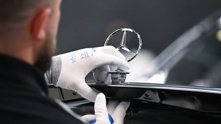 Ein Arbeiter bei Mercedes-Benz montiert im Mercedes-Benz-Werk Sindelfingen in der Factory 56 einen Mercedes-Stern auf ein Fahrzeug der S-Klasse. Die IG Metall lehnt eine 38-Stunden-Woche ab und will bei 35 Stunden bleiben.
