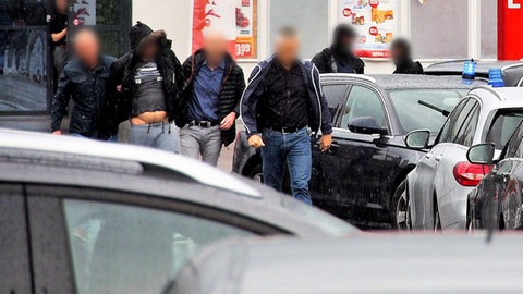 Ein Verdächtiger (2.v.l) im Missbrauchsfall in Freiburg wird von Polizisten festgenommen.