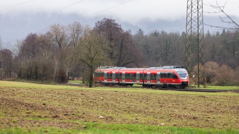Links fährt ein roter Zug