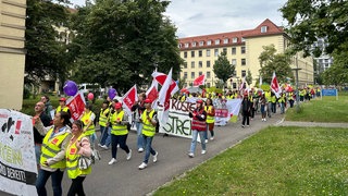 Die Demonstrierenden tragen gelbe Warnwesten, viele haben Transparente und Schilder dabei.