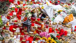 Kerzen und Blumen liegen vor dem Eingang der Waldbachschule in Offenburg.