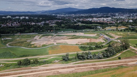 Auf dem Hügel wird Erde für die Aufschüttung des neuen Stadtteils von umliegenden Baustellen gesammelt.
