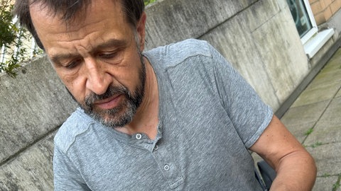 Der Wissenschaftler Pascal von Sengbusch untersucht ein Stück Moos. Das Moos liegt auf einer kleinen Petrischale, in seiner Hand hält er ein Messgerät.