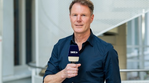 Mann mit blauem Hemd und SWR Mikrofon