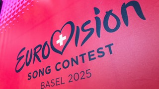 Das Logo des Eurovision Song Contests (ESC) 2025: in dunkler Schrift auf pinkem Hintergrund - samt einem Herz mit dem Schweizer Kreuz.