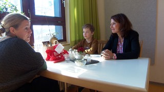 Die Bundestagsabgeordnete der SPD Rita Schwarzelühr-Sutter (rechts) unterhält sich mit einer Familie in der Rehaklinik Schuppenhörnle. 