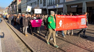 Menschen demonstrieren vor dem Freiburger Münster.