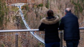 Menschen stehen auf der "Blackforestline", einer Hängebrücke in Todtnau. In Rottweil soll nun ein ähnliches Tourismusprojekt starten.  