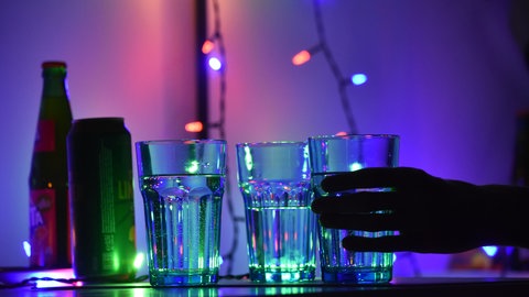 Gläser mit Getränken stehen auf einem Tisch bei einer Party.