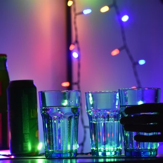 Gläser mit Getränken stehen auf einem Tisch bei einer Party.