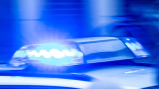 Ein Streifenwagen der Polizei ist mit Blaulicht im Einsatz. 