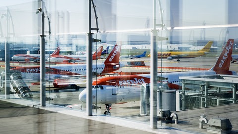 Maschinen der britischen Fluggesellschaft Easyjet stehen am Flughafen EuroAirport. Zu sehen sind ebenfalls Frachtmaschinen von DHL.