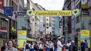 Menschen gehen auf der Eurovisionsstraße im Rahmen des 69. Eurovision Song Contest (ESC). Der ESC findet vom 10. bis 17. Mai 2025 in Basel statt.
