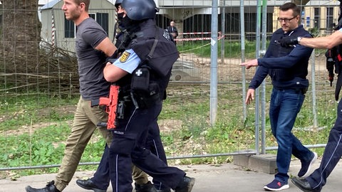 Einer der vermeintlichen Attentäter der Amokübung an der Uniklinik freiburg wird von Polizisten abgeführt