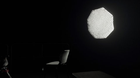In einem dunklen Raum steht ein Stuhl vor einer großen Lichtquelle. Ein Arzt, der anonym bleiben möchte, berichtete von der Arbeitszeiterfassung an einer der vier Unikliniken in BW.