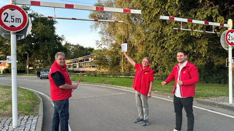 ACE-Mitarbeiter zeigen auf Einfahrtsbeschränkung