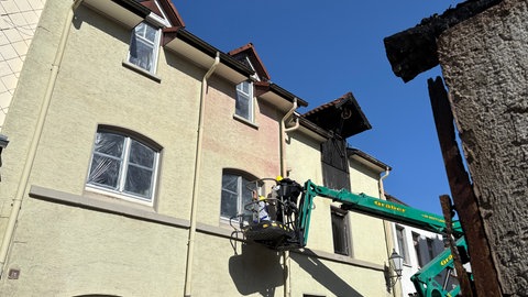 Die kaputten Fenster der angrenzenden Gebäude beim Brand in Villingen werden mit Folie abgeklebt.