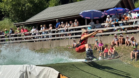 Eine Teilnehmerin des Waterslide-Wettkampfs hat es bis zum anderen Ende des Beckens geschafft. 