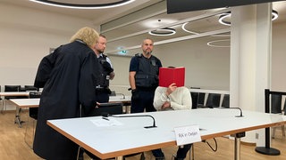 Verteidigerin mit einem Angeklagten vor der Urteilsverkündung der Beil-Attacke.