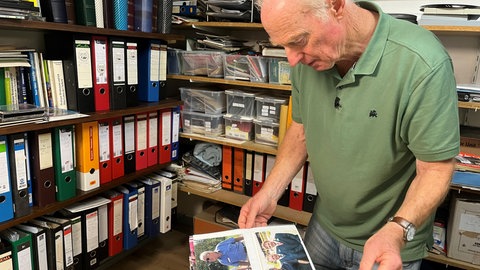 Rolf Schill blättert durch ein Album mit Fotos.Der Serienkenner hat jede Menge Fotos, Zeitungsartikel und andere Dokumente rund um die "Schwarzwaldklinik" gesammelt.
