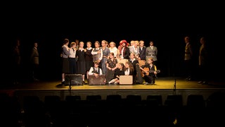 Schülerinnen und Schüler auf der Bühne bei einem gemeinsamen Theaterprojekt