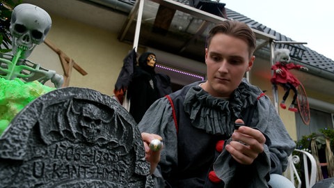 Julian Pyhrr, der einundzwanzigjährige Erfinder und Erbauer der Geisterbahn in seinem Elternhaus, wie er einen Styropor-Grabstein bemalt