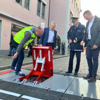 Die mobilen Zugangssperren "Armis One" werden von Thomas Barth von der FWTM, dem Freiburger Ordnungsbürgermeister Stefan Breiter, Freiburgs Polizeivizepräsident Uwe Oldenburg und dem FWTM-Geschäftsführer in Augenschein genommen. 