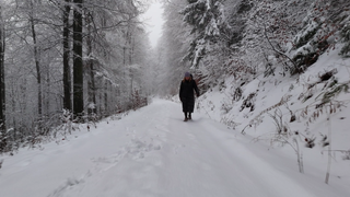 Eine Frau läuft durch den Schnee im Wald