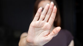 Zusehen ist die ausgestreckte Hand einer Frau.