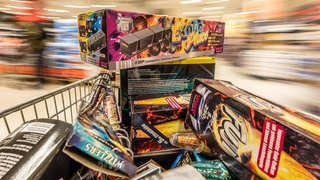 Ein Einkaufswagen mit Feuerwerk wird durch einen Supermarkt geschoben. Am Montag (29.12.) hat der Böllerverkauf begonnen. In Kehl gab es einen größeren Ansturm und auch direkt Zwischenfälle.