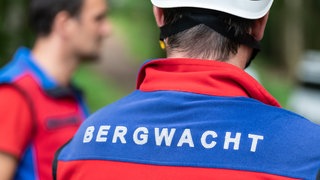 Der Schriftzug "Bergwacht" ist auf der Jacke eines Mitglieds der Bergwacht zu sehen. 