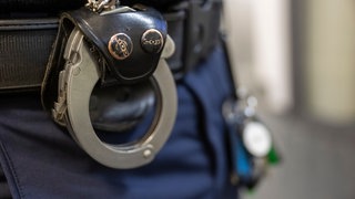 Ein Polizist mit Handschellen an seinem Gürtel. 