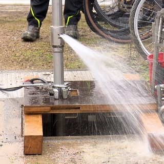 Eine Pumpe ist im Boden eingebaut. Oben kommt Wasser heraus.