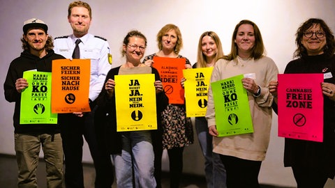 Vertreter der Stadt Waldshut-Tiengen zeigen bunte Plakate mit Slogans zum Jugendschutz. 