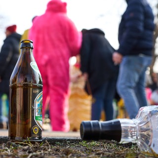 Leere Alkoholflaschen stehen am Straßenrand bei einer Fastnachtsveranstaltung. 