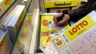 Lottospiele füllt einen Lottospielschein aus