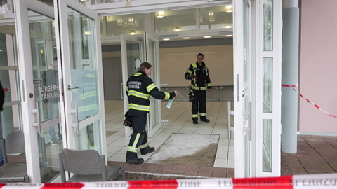 Feuerwehrleute reinigen einen Eingangsbereich nach einem Buttersäure-Anschlag