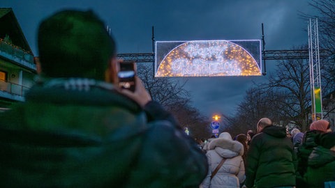 Jemand fotografiert die Ramadan Beleuchtung mit seinem Handy.