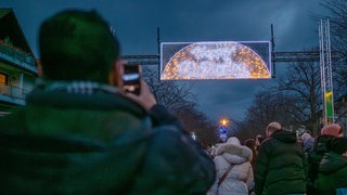 Jemand fotografiert die Ramadan Beleuchtung mit seinem Handy.