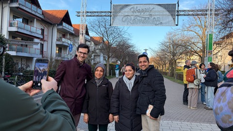 Freiburgs Oberbürgermeister Martin Horn und Vertreter muslimischer Gemeinden unter der Leuchtinstallation Happy Ramadan.